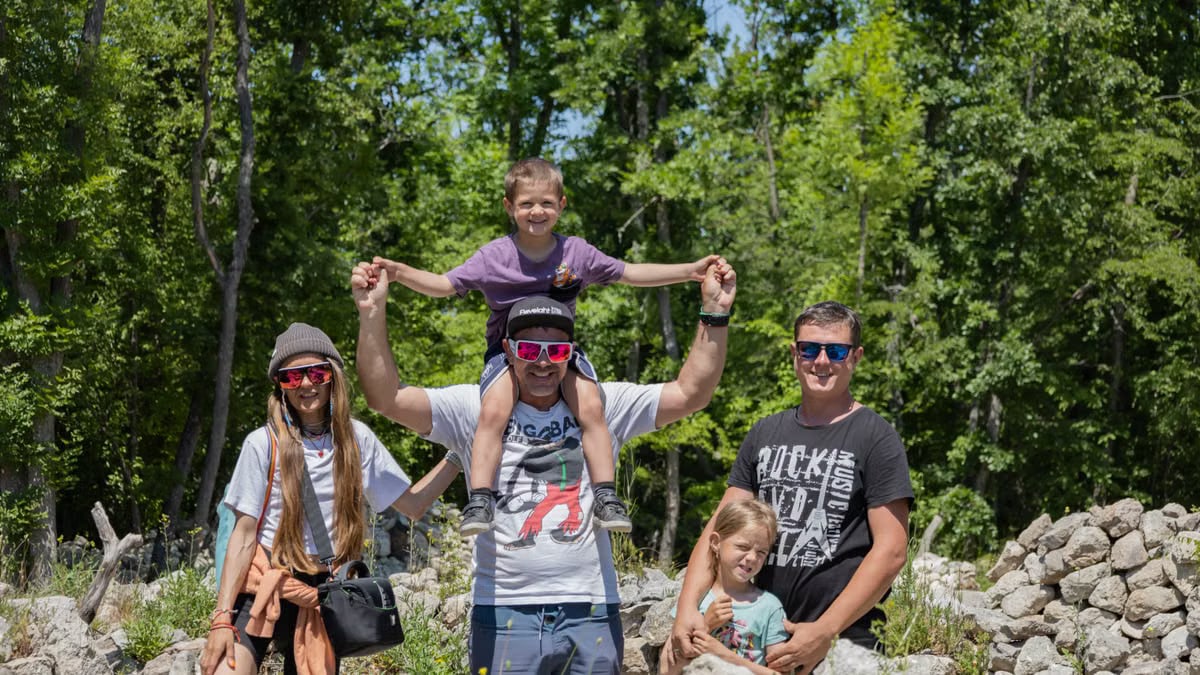 A joyful family enjoying a sunny day outdoors, captured in a lively and happy moment.